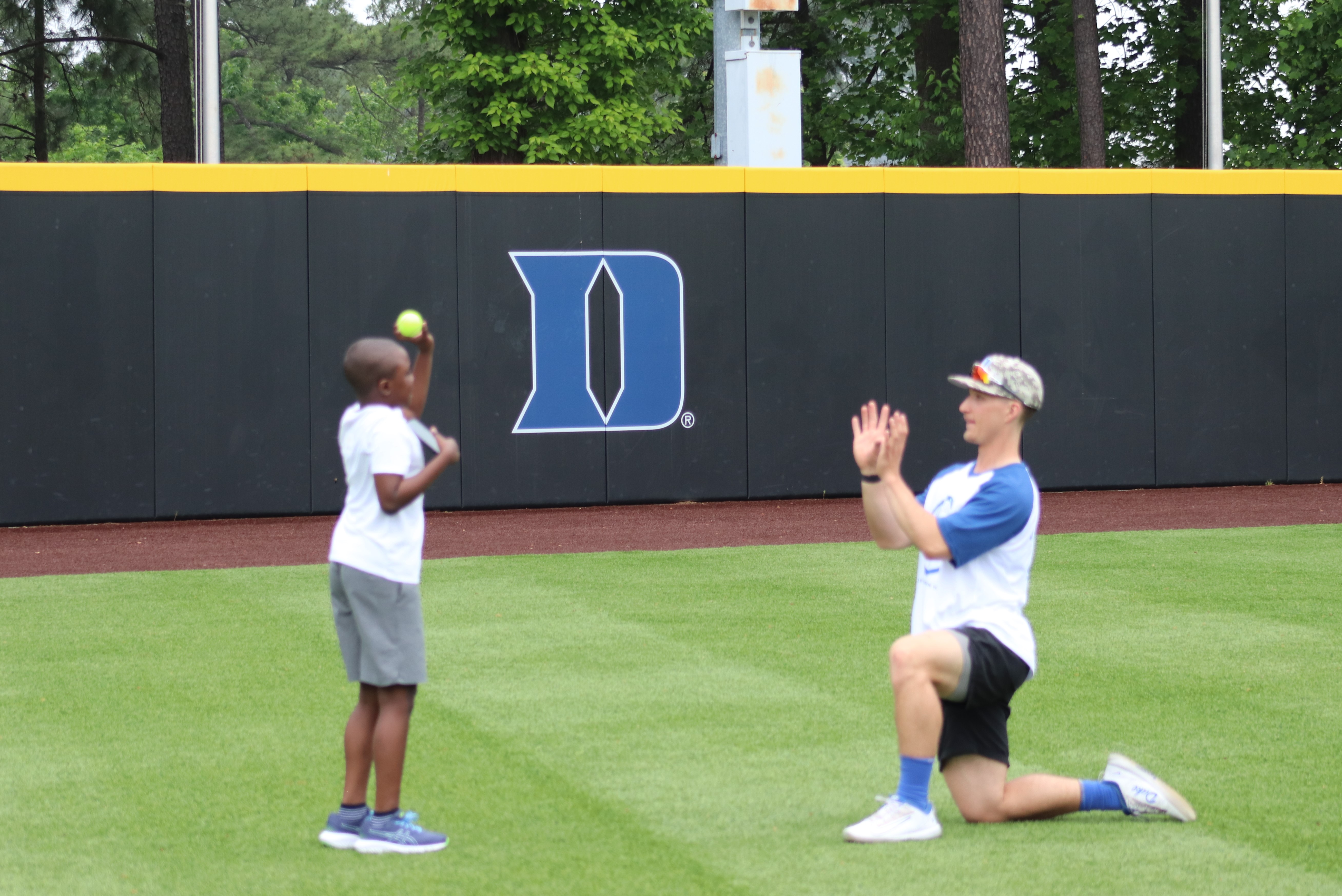 Duke baseball player and child throwing ball