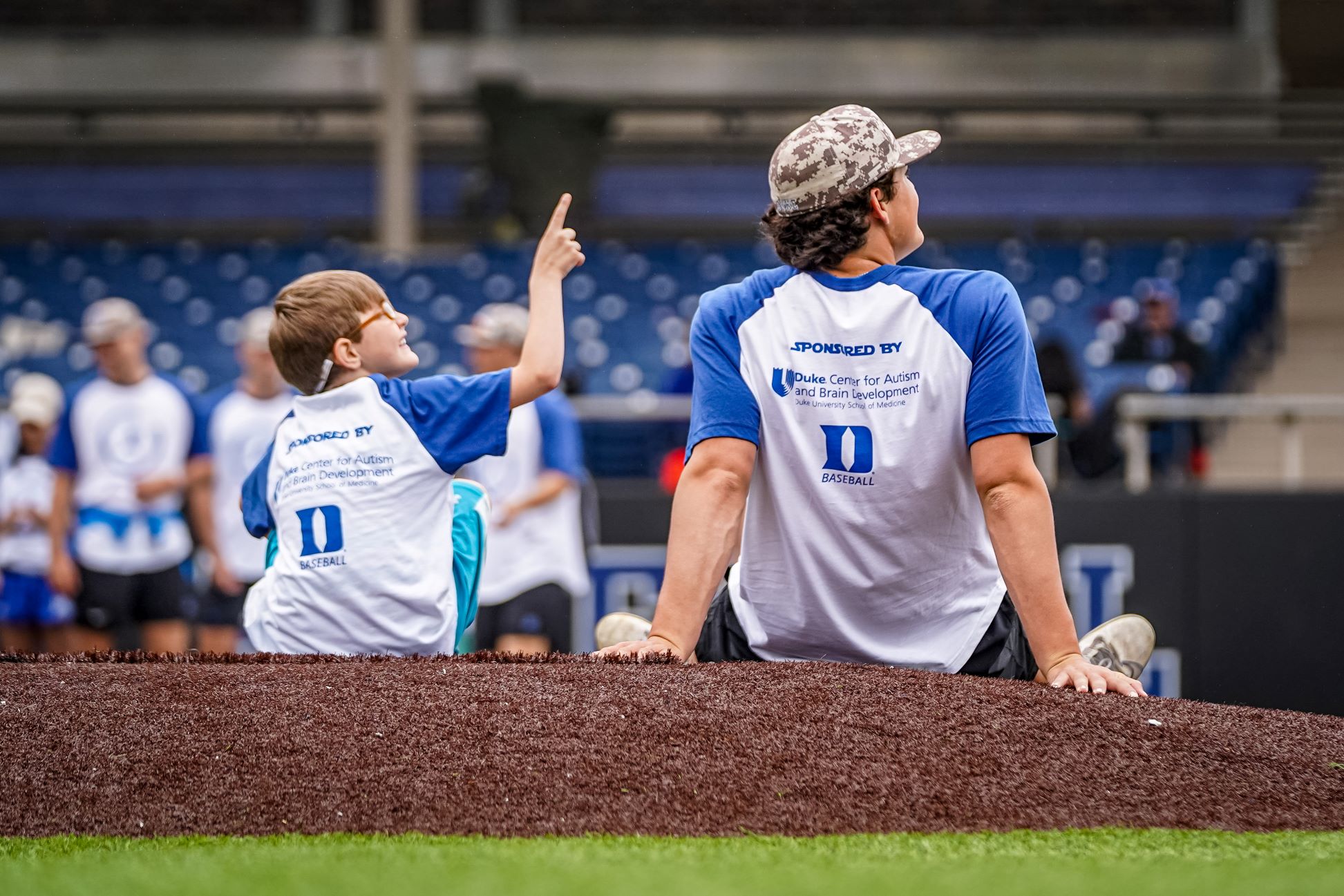 Duke baseball player and child on the field