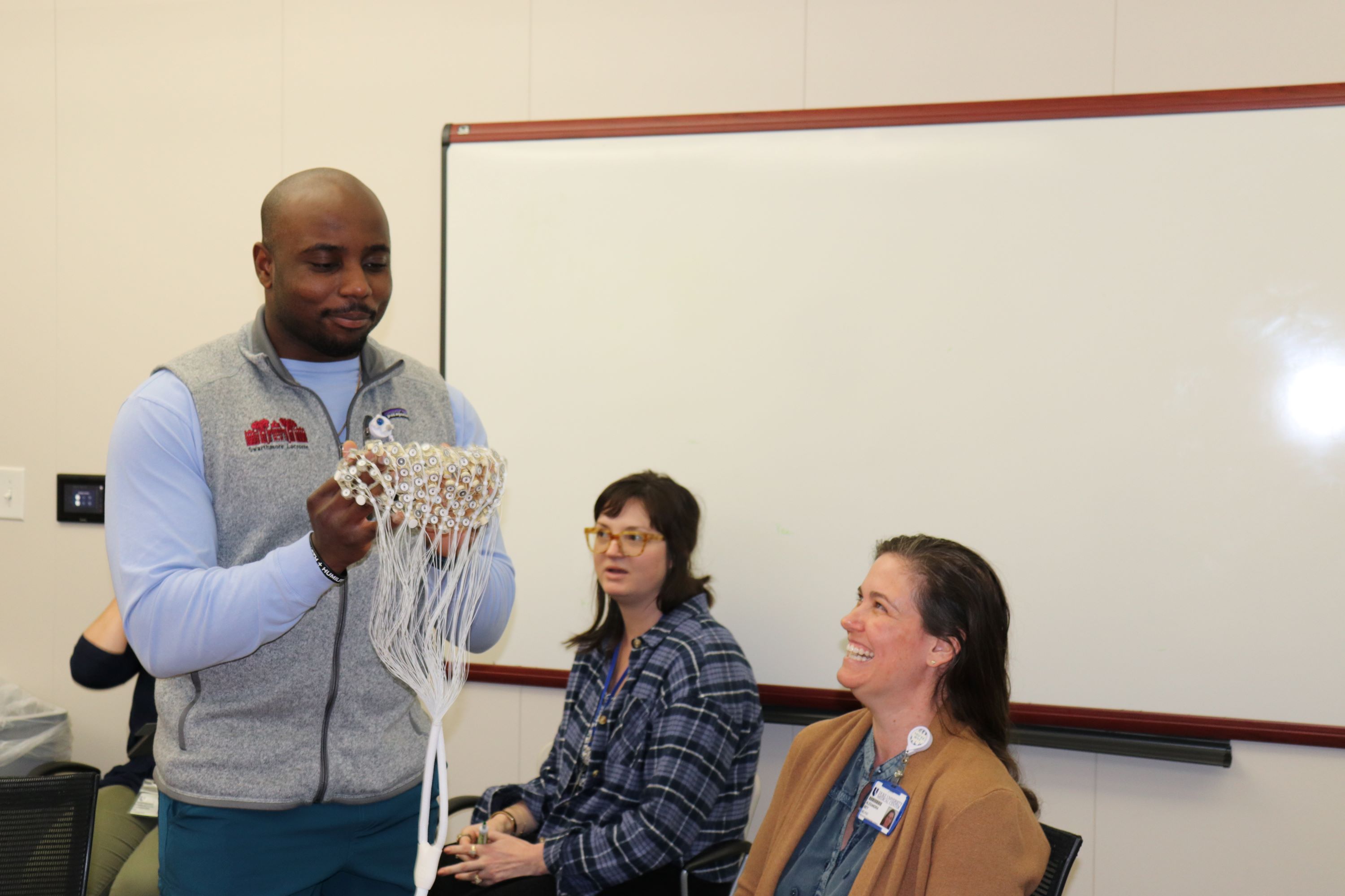 David Akinsooto prepares to administer and EEG net