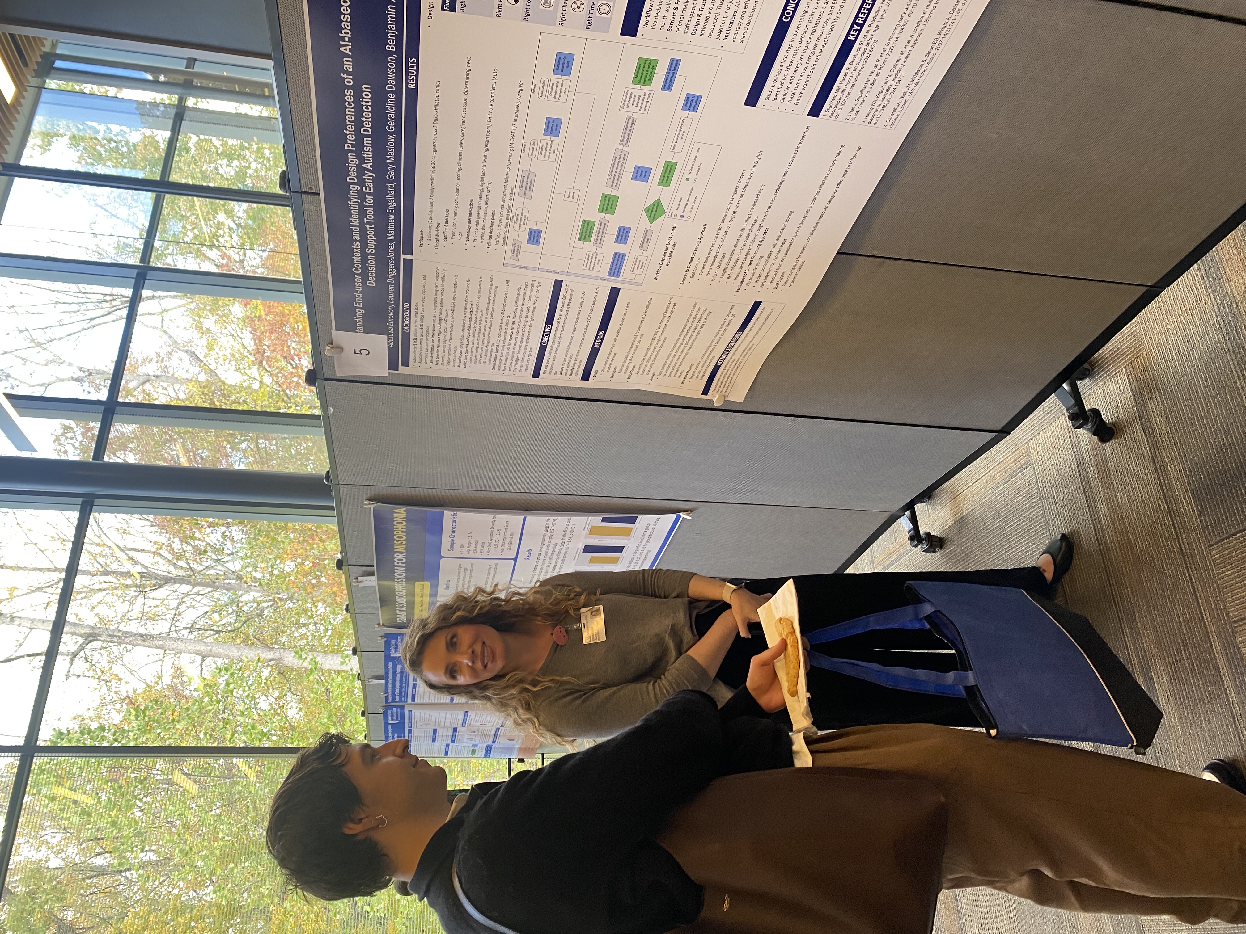 Lauren Driggers-Jones speaks to Owen Wilson at a conference poster