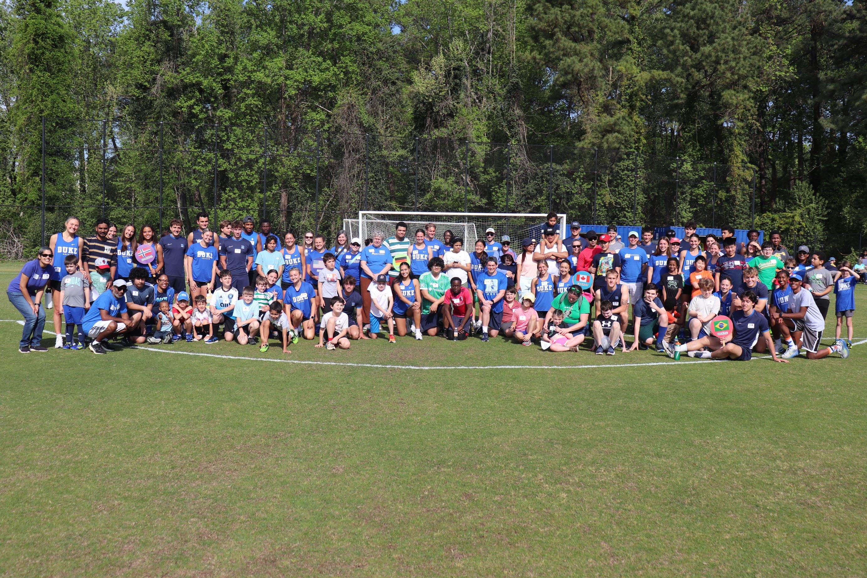 full group photo of 50+ children and Duke mens and womens soccer players