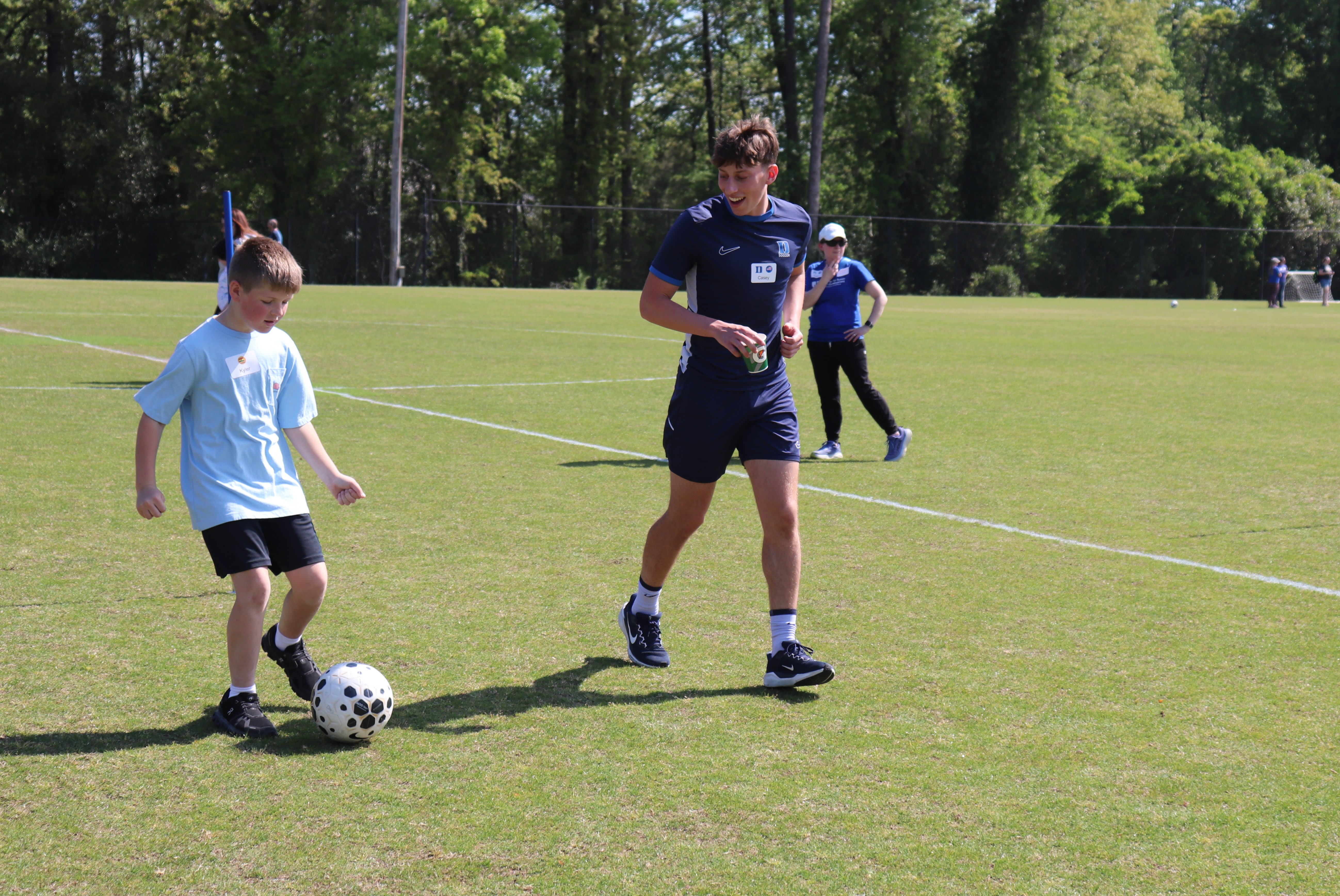 a mens soccer player alongside a young boy