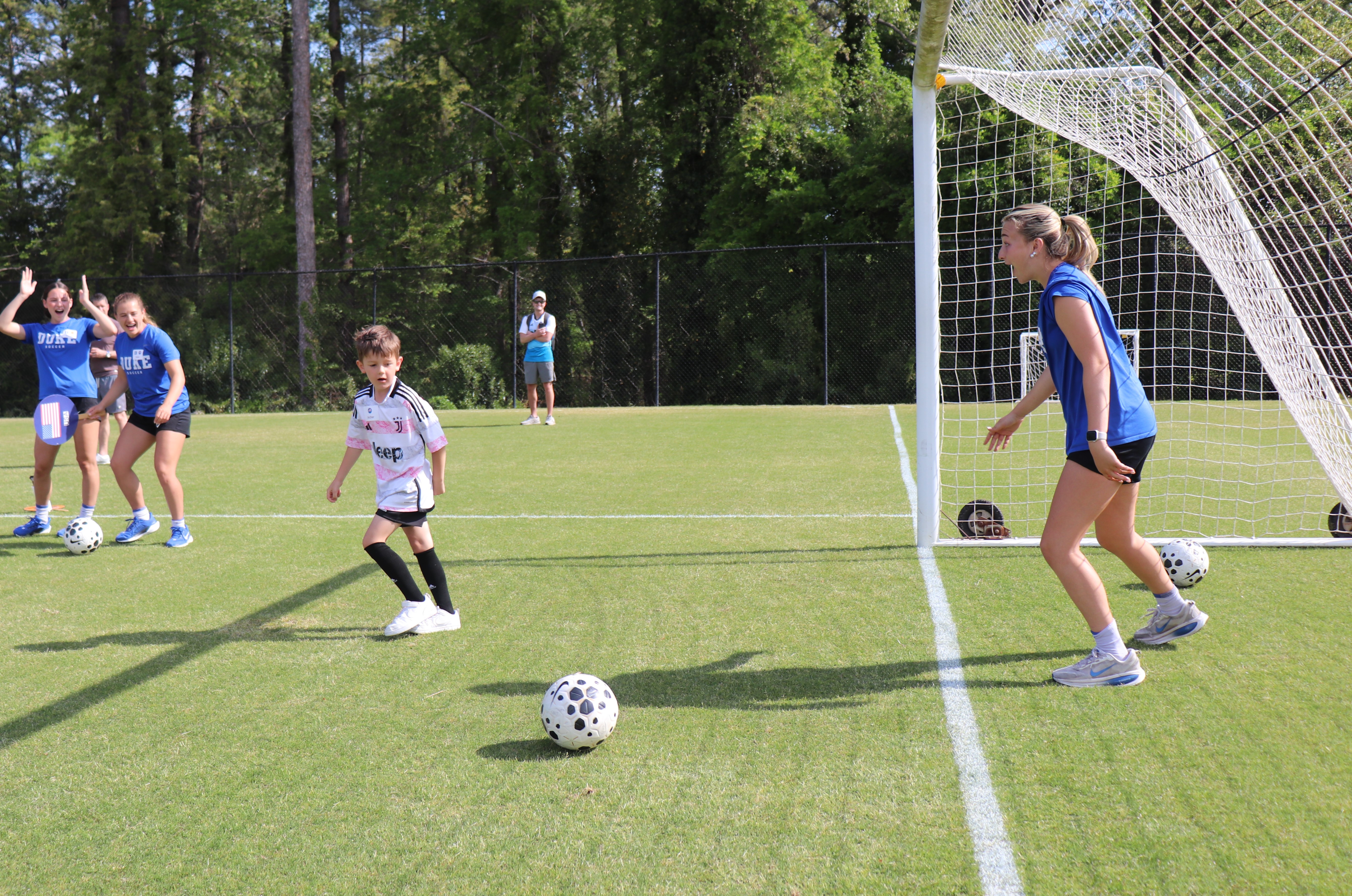 boy kicking a soccer ball into the goal