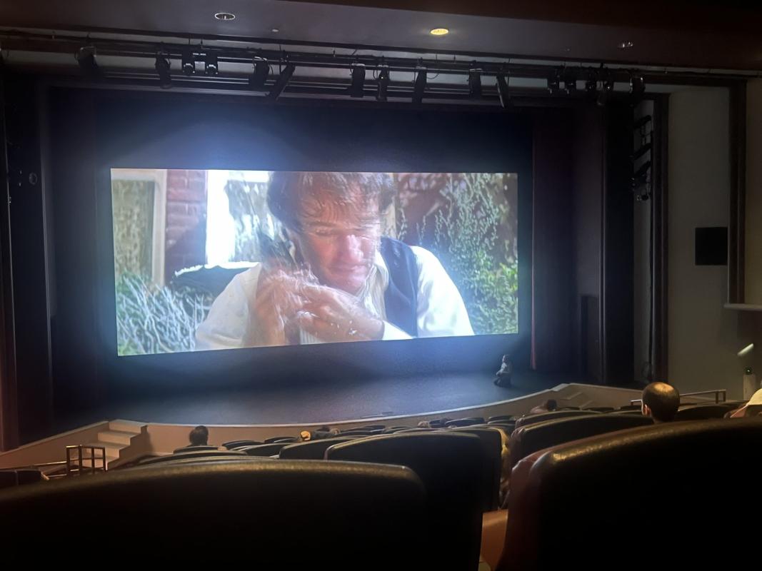 interior of movie theater showing actor Robin Williams on the screen