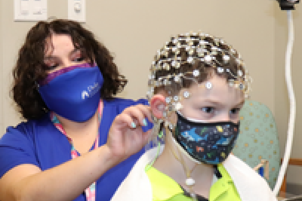 researcher puts on EEG hat for boy