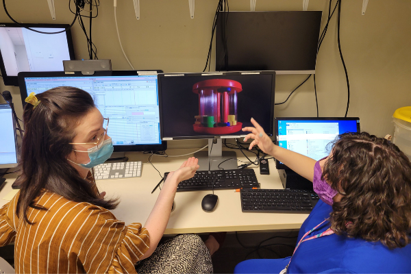 two researchers interacting in lab reading computer data