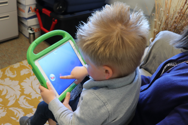 child working on iPad with autism app