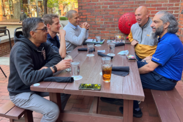men talking outside at a picnic table