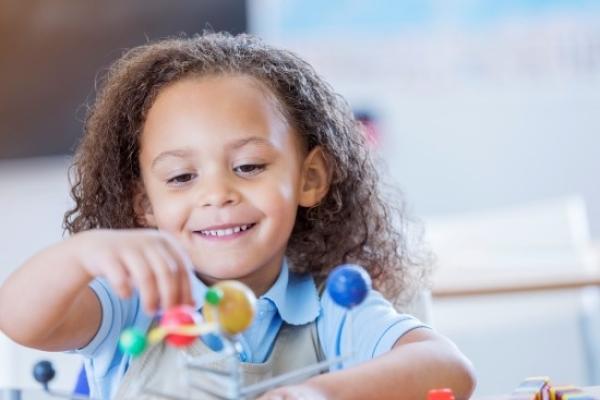 Young girl playing with a solar system toy