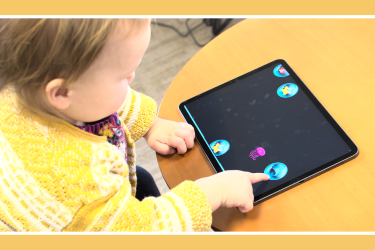 Toddler playing a game on a tablet.