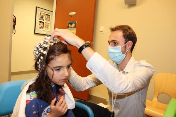 researcher fitting EEG cap to child