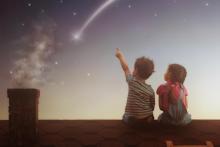 two children watch a shooting star