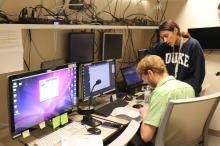 Two employees look at computer data together