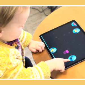 Toddler playing a game on a tablet.